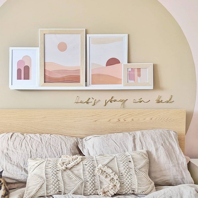 Світла спальня з ліжком ІКЕА, пледом, подушками та картинами на стіні