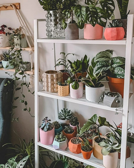 Сучасний офіс з чорним стелажем ІКЕА, заповненим папками та офісним приладдям.