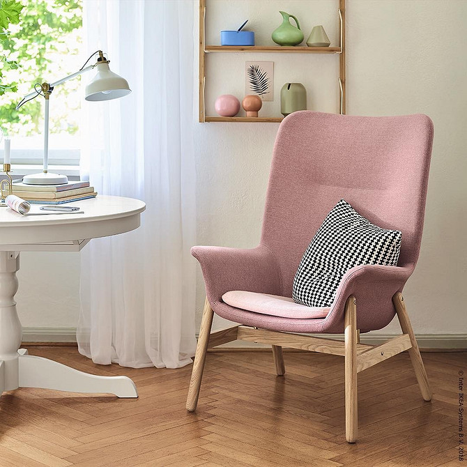 Зручне ротангове крісло ІКЕА в світлій вітальні, натуральні матеріали, дизайн інтер'єру.