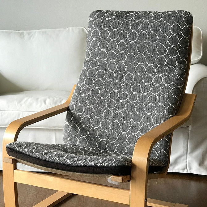 Зручне крісло ІКЕА з подушками у вітальні, ідеальне для відпочинку та релаксації.