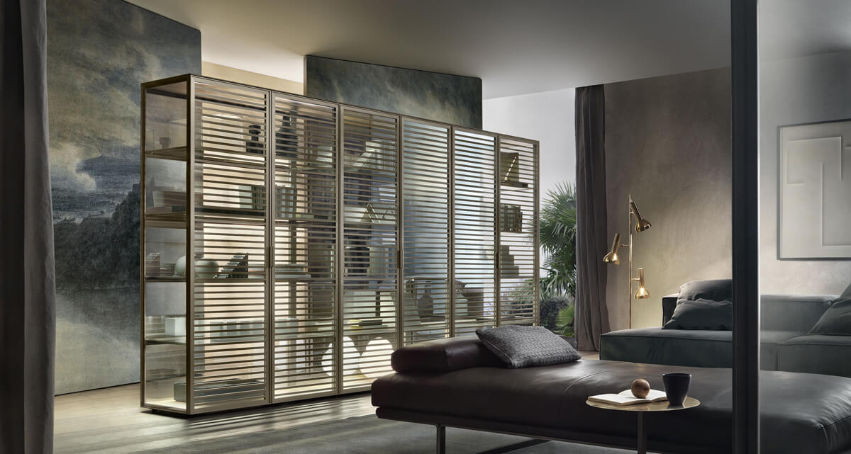 Світла спальня з гардеробною системою зберігання, дзеркалом та зручним кріслом