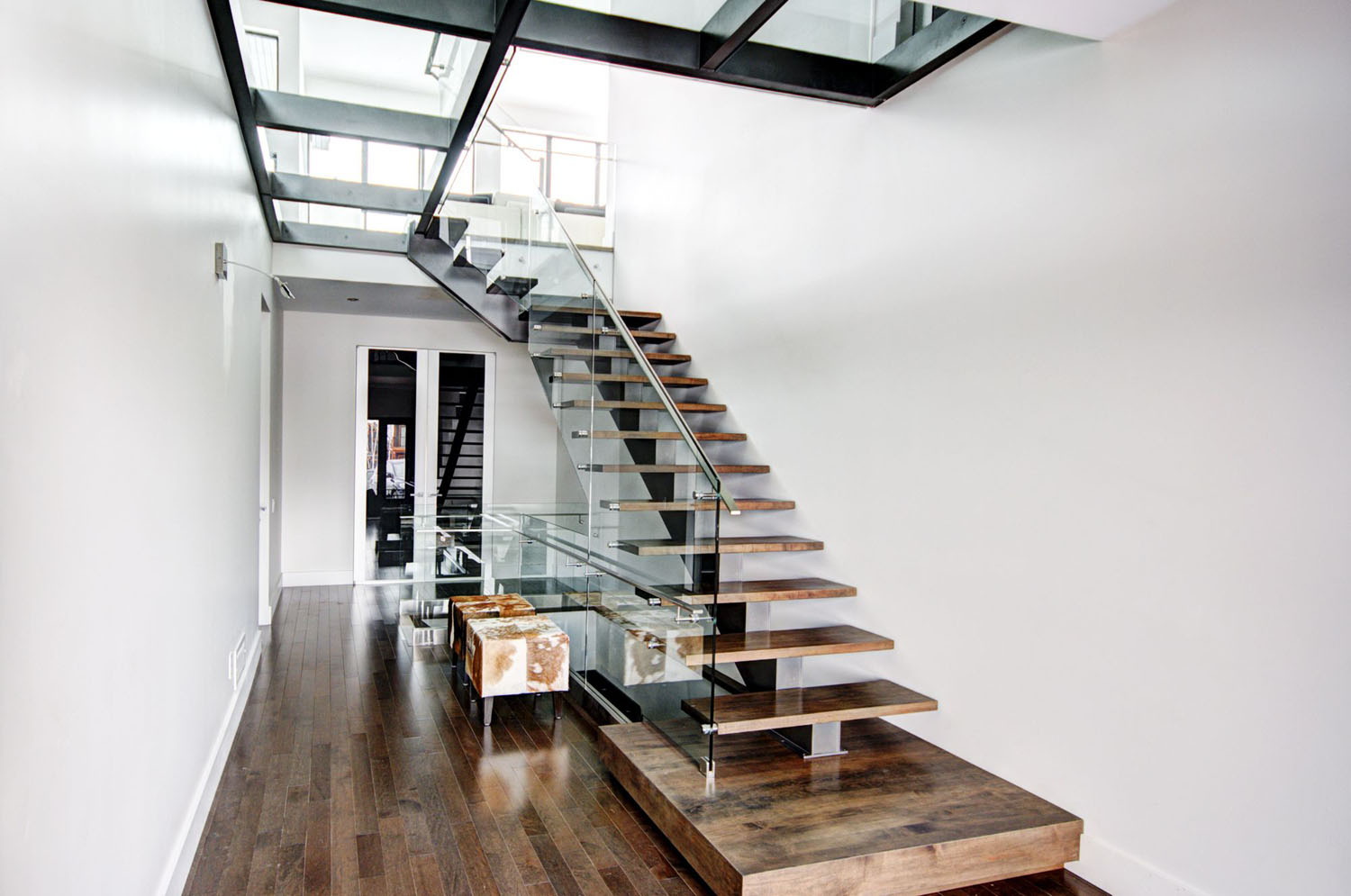 Сучасні сходи в приватному будинку: мінімалістичний дизайн з використанням скла та металу.