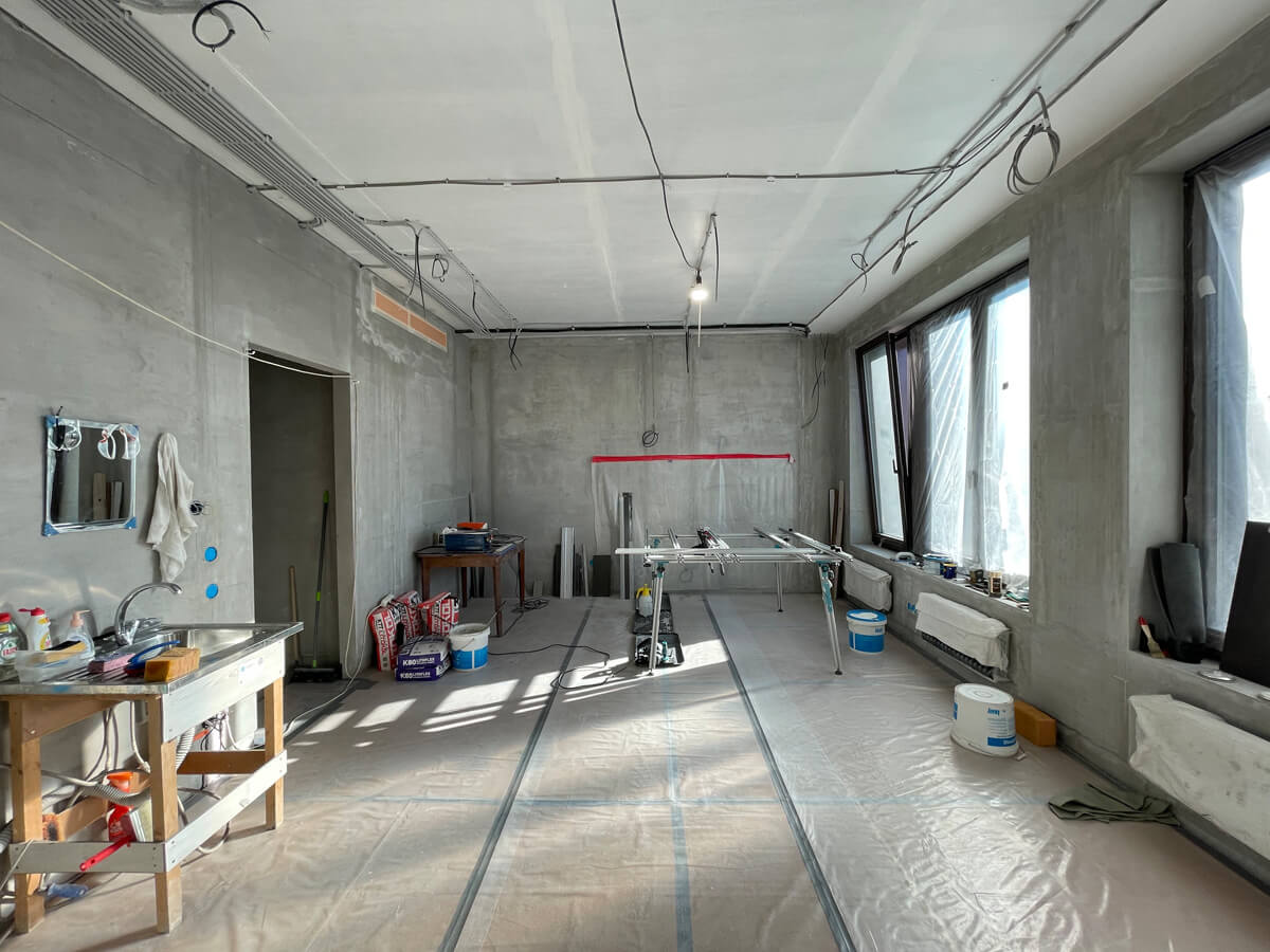 Процес монтажу електропроводки: кріплення кабелів до стіни в гофрованій трубі.