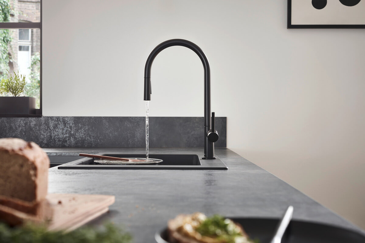 Сучасний кухонний змішувач з висувним виливом для зручного миття посуду.