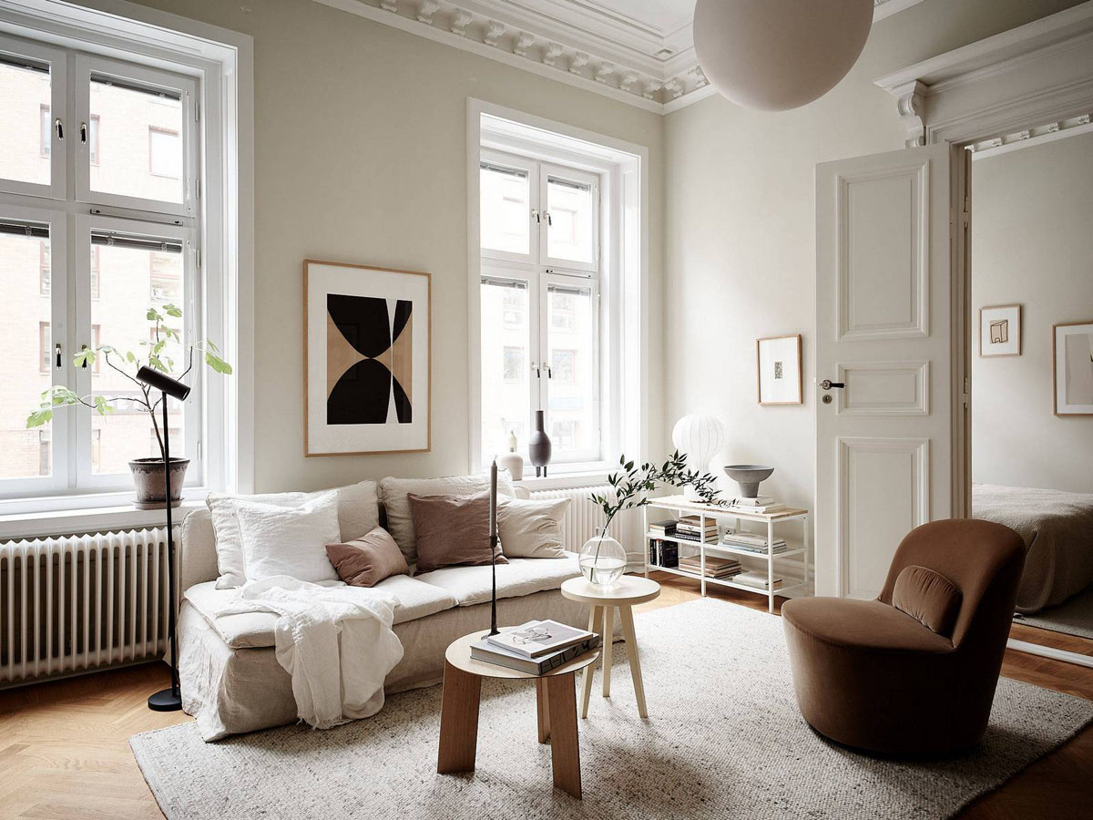 Нейтральна колірна палітра в інтер'єрі вітальні: диван, килим, декоративні подушки, освітлення