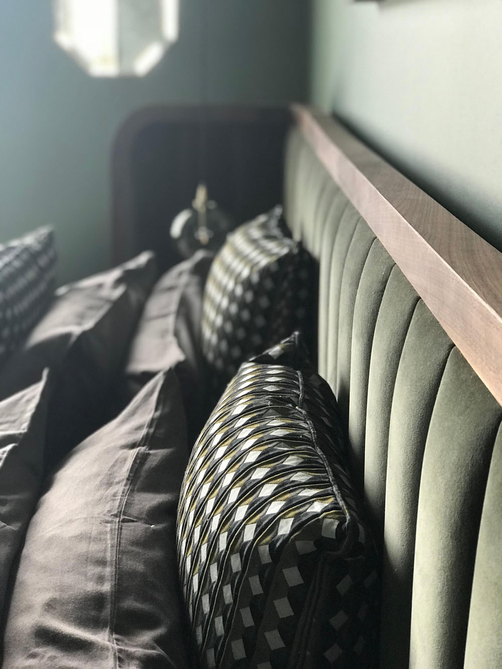 Зелена спальня з дерев'яними елементами для створення еко-стилю в інтер'єрі.