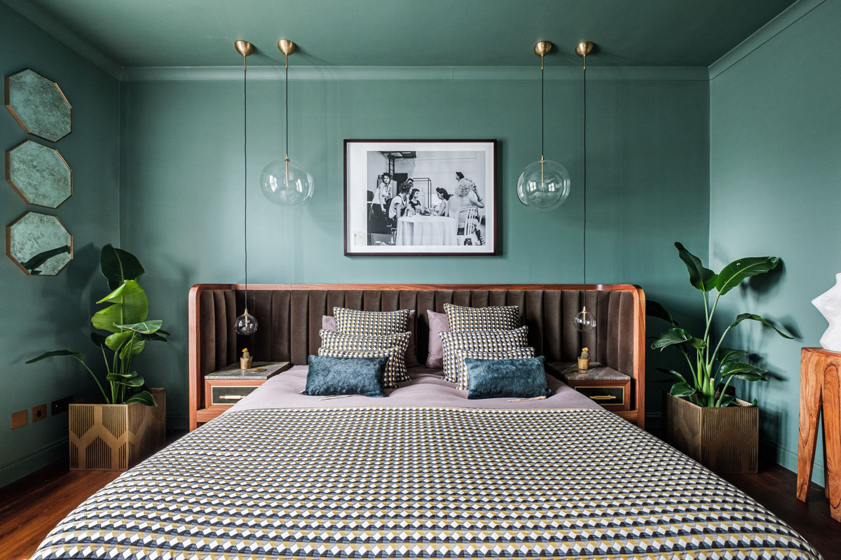 Інтер'єр спальні в зелених тонах з великим вікном та природнім освітленням.