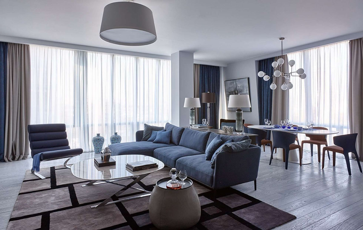 Елегантна синя кухня: шафи глибокого синього кольору з золотою фурнітурою та мармуровою стільницею.