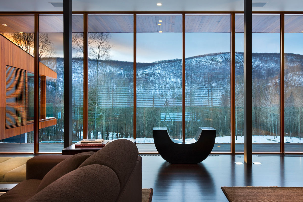 Сучасна вітальня з панорамним склінням, що відкриває вид на зелений сад. Вікна в підлогу.