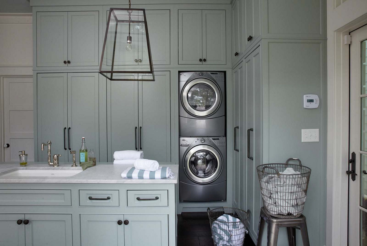 Інтер'єр пральні кімнати з полицями для рушників та пральним приладдям.