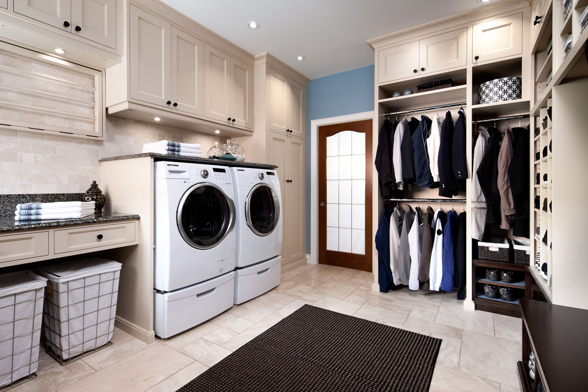 Сучасний дизайн пральні кімнати з шафами для зберігання та кошиками для білизни.