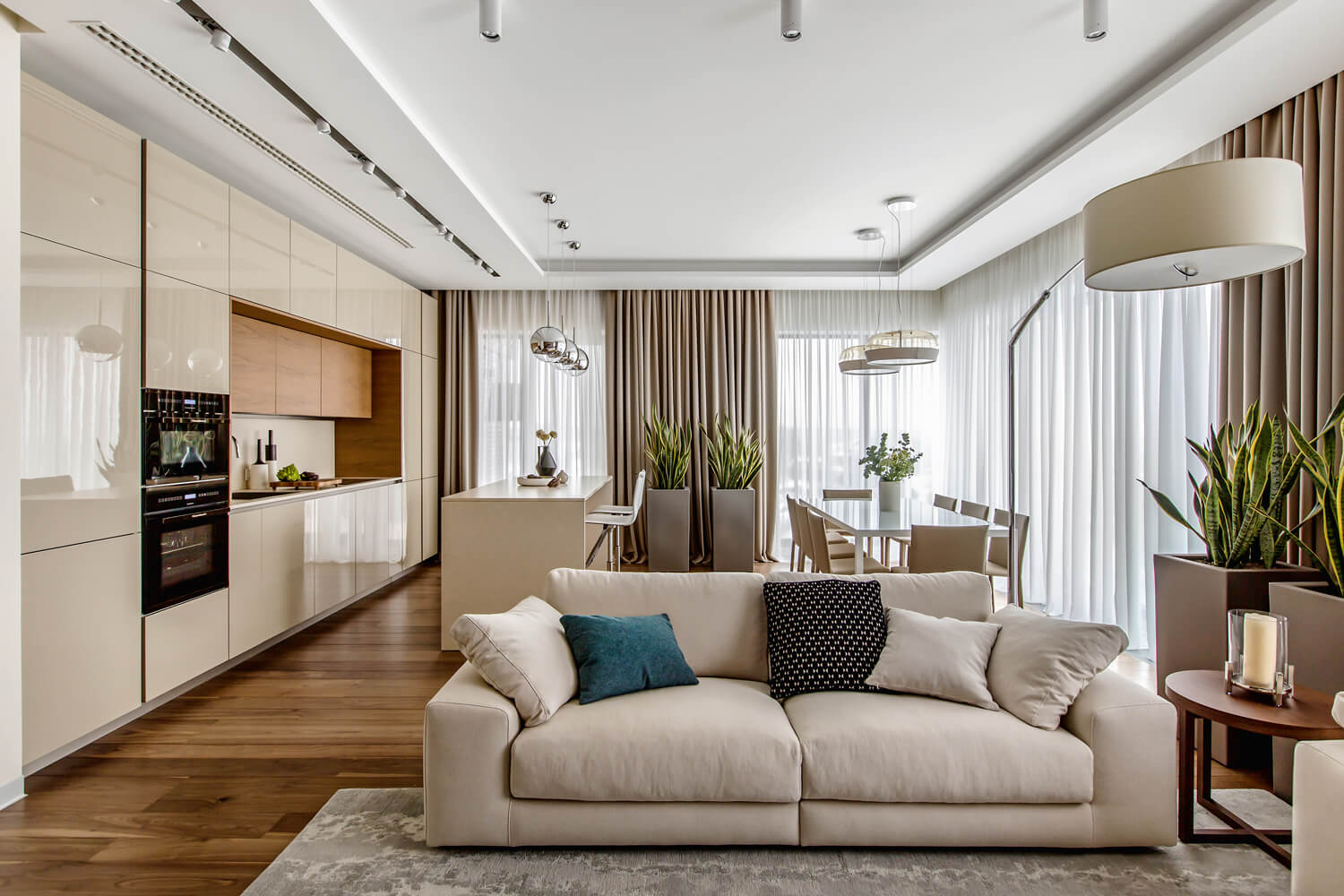 Сучасний дизайн трикімнатної квартири: світла вітальня з мінімалістичним інтер'єром та великим вікном.