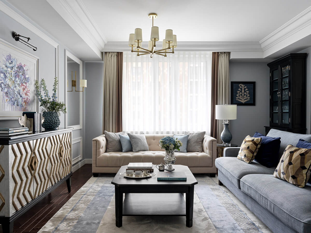 Інтер'єр вітальні в неокласичному стилі з м'якими меблями та декоративними елементами.