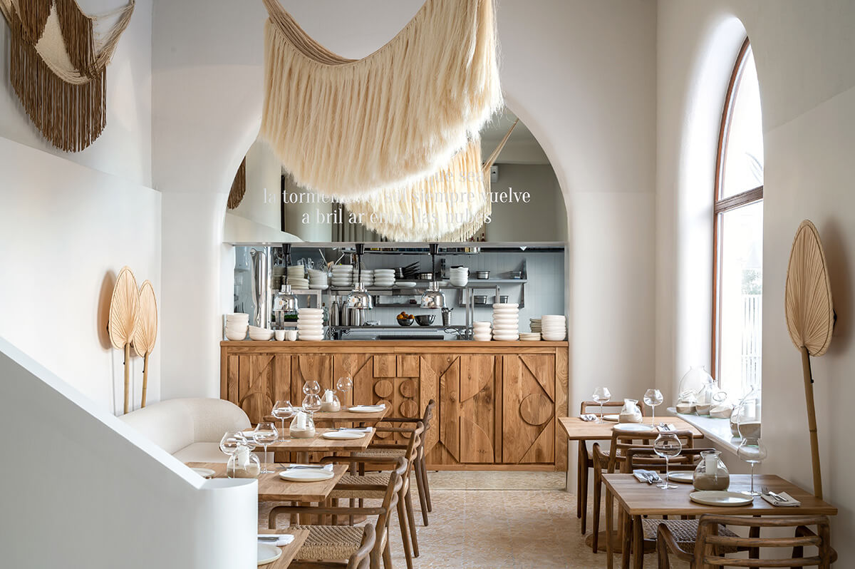 Дизайн кухні в богемному стилі: дерев'яні полиці, посуд ручної роботи та зелень.