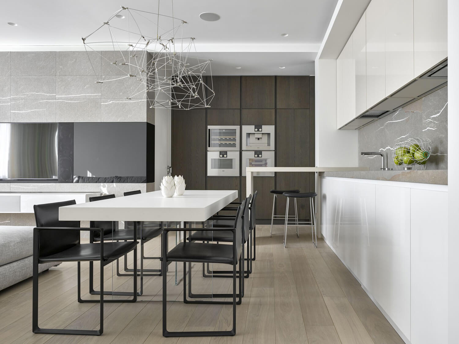 Інтер'єр кухні-вітальні в приватному будинку з використанням різних кольорів для зонування.