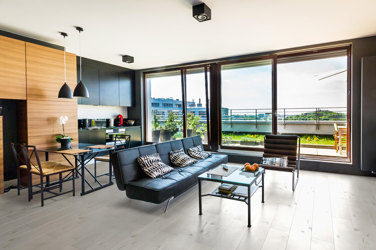 Сучасна кухня-вітальня з великими вікнами та мінімалістичним дизайном у приватному будинку.