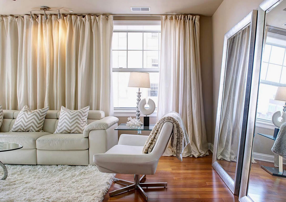 Елегантні штори для вікон: сучасний дизайн вітальні з великим панорамним вікном.