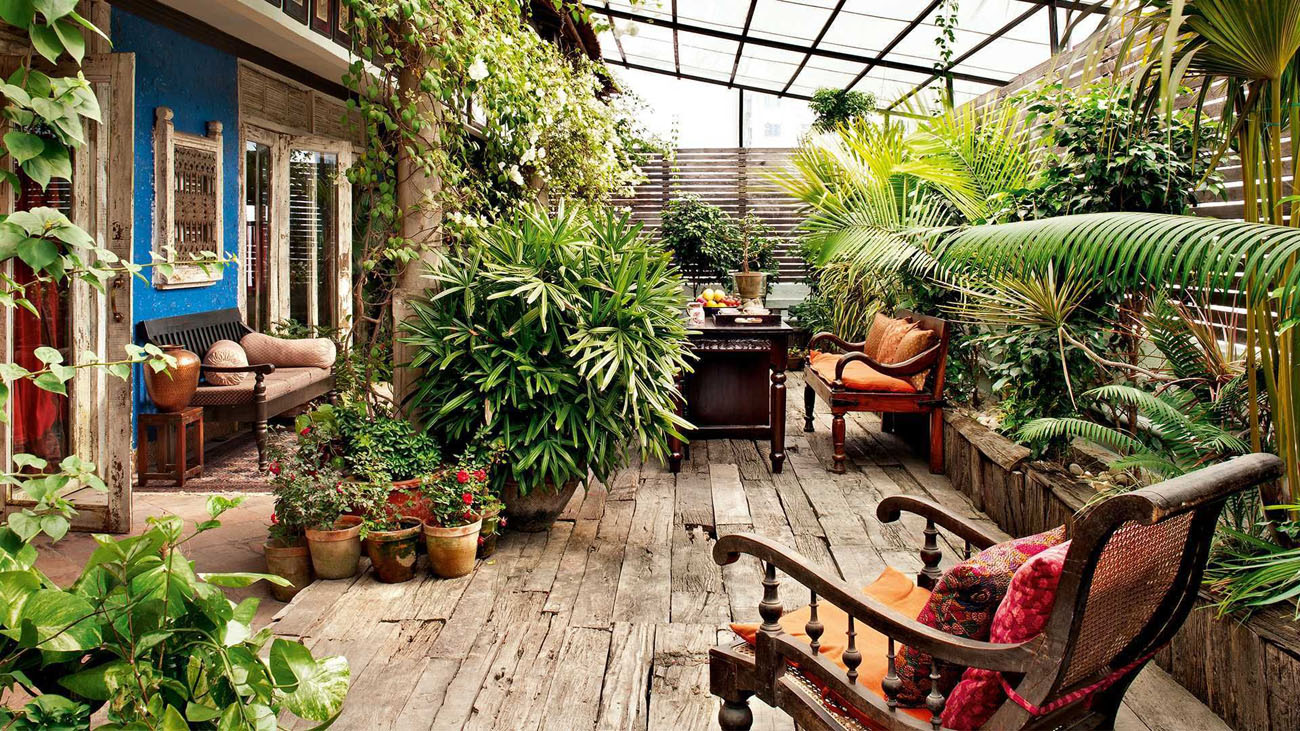 Декор зимового саду на балконі: пледи, подушки та ліхтарики для створення затишку.