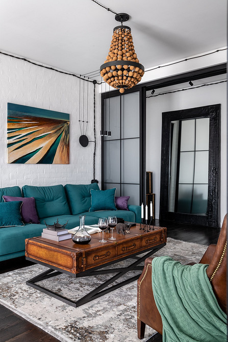 Круглий журнальний столик у вітальні з м'яким килимом та декоративними подушками.