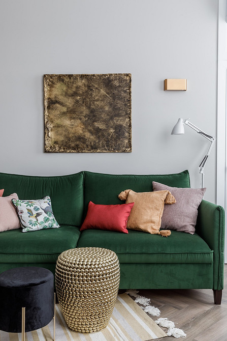 Круглий журнальний столик з мармуру у вітальні з м'якими меблями та килимом