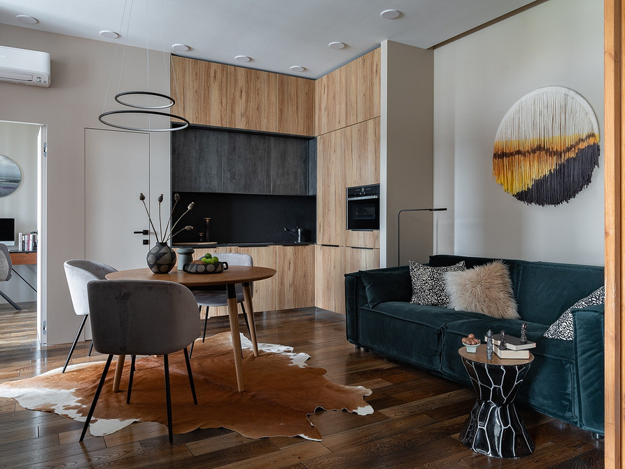 Скляний журнальний столик у світлій вітальні з панорамними вікнами та рослинами.