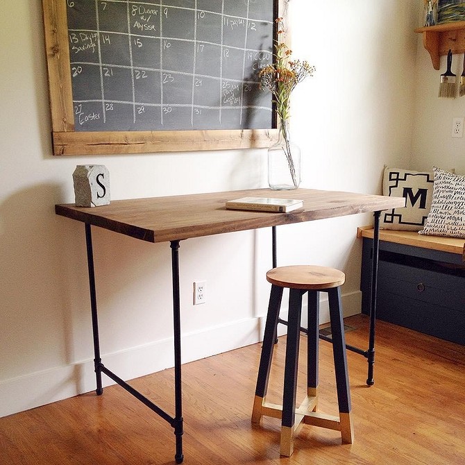 Дизайнерський стіл з металевими ніжками з водопровідних труб в інтер'єрі лофт.