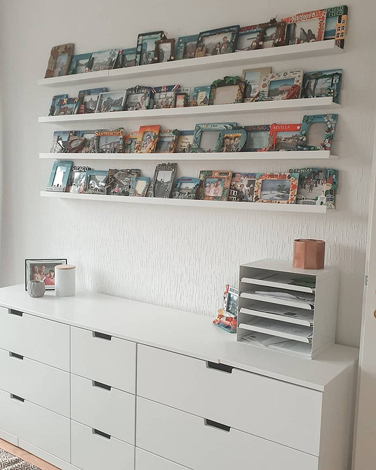 Кілька вузьких полиць IKEA утворюють стильний декор стіни з книгами та рослинами