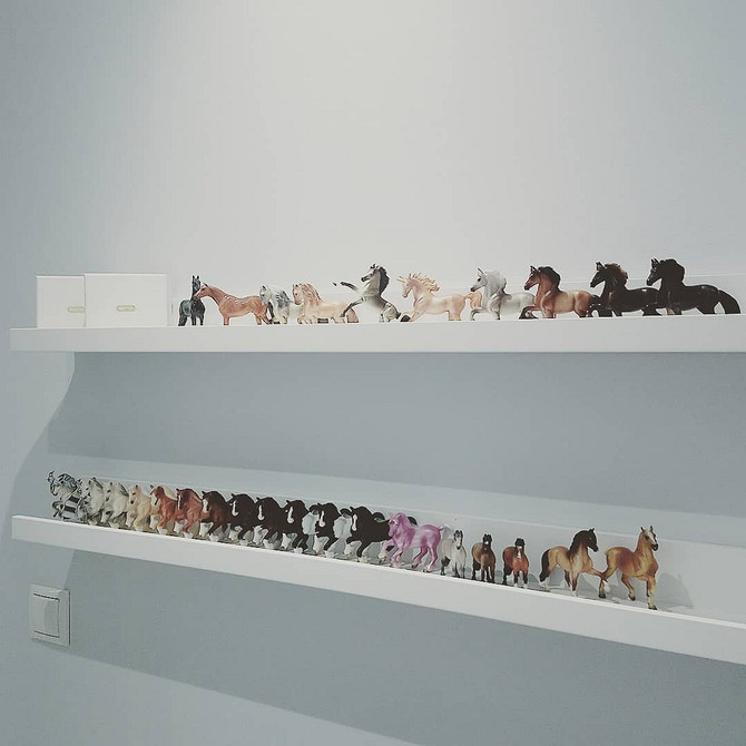 Вузькі полиці IKEA у дитячій кімнаті для зберігання іграшок та книг біля ліжка