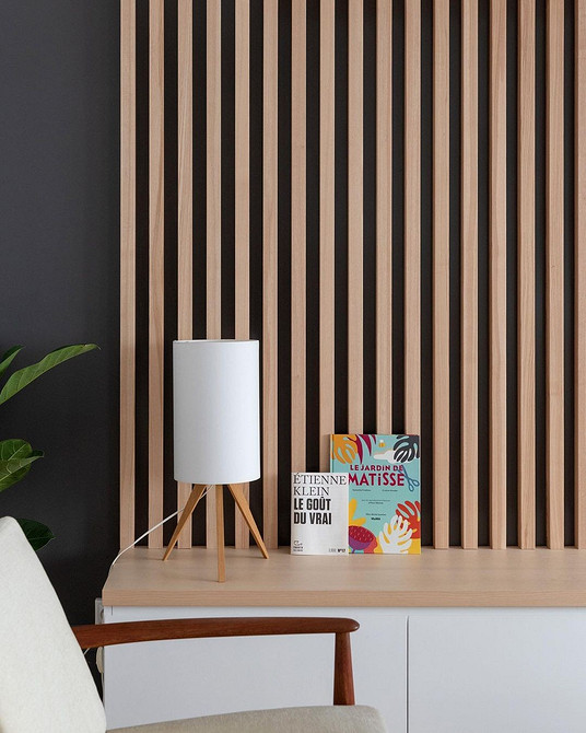 Сучасний дизайн вітальні з мінімалістичною стінкою та акцентним декором на полицях.