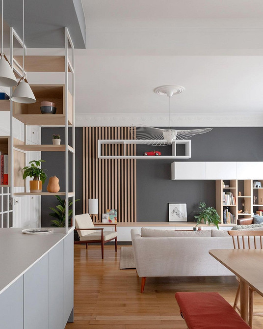 Дизайн вітальні з великою стінкою, що включає полиці, шафи та місце для телевізора.