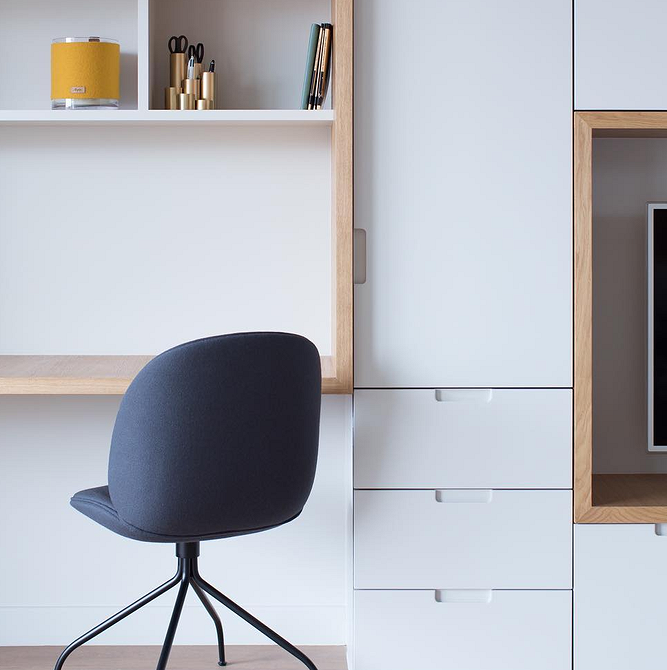 Світла вітальня з білою меблевою стінкою, що поєднує функціональність та елегантний дизайн.