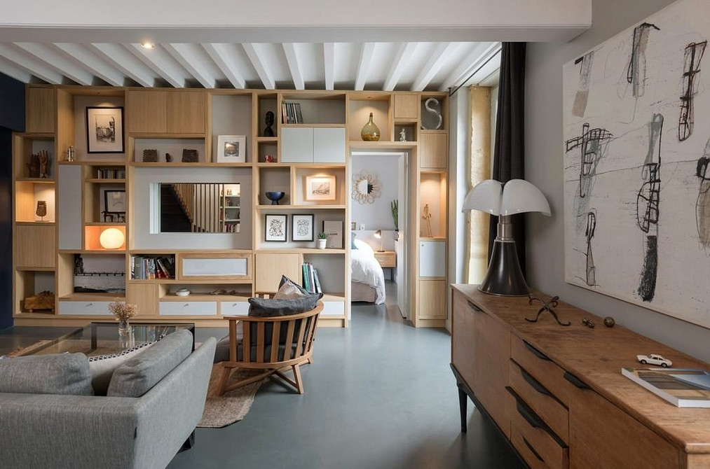 Стильна вітальня з темною меблевою стінкою, що створює контраст зі світлими стінами.