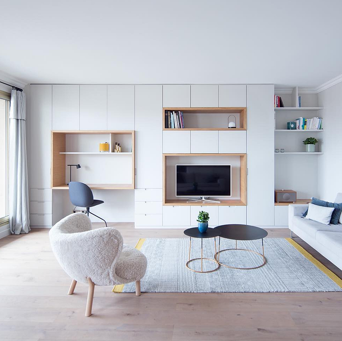 Інтер'єр вітальні з сучасною меблевою стінкою, телевізором та декоративними елементами.