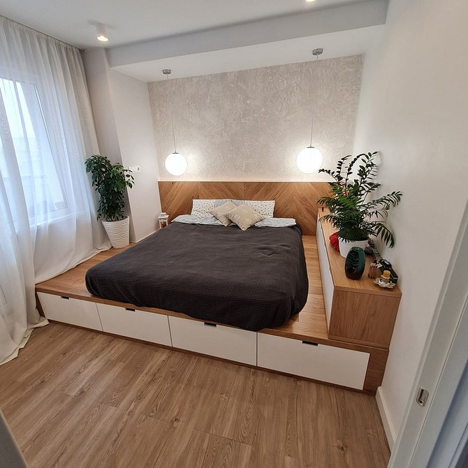 Функціональний інтер'єр з подіумом: спальня на подіумі з додатковим місцем для зберігання.