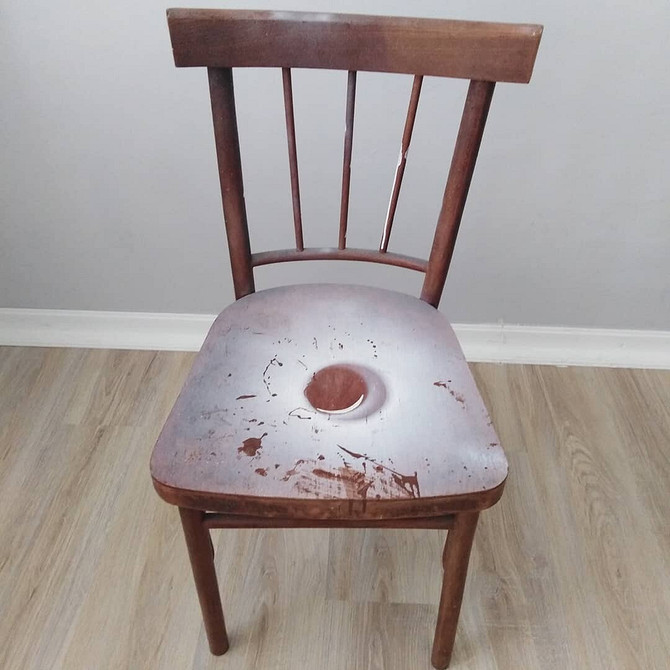 Зображення процесу фарбування дерев'яного стільця у яскравий колір