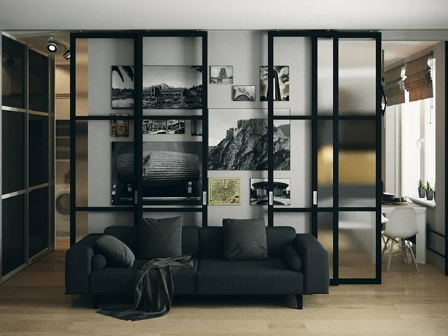 Інтер'єр з темними меблями, світлі стіни, яскравий килим як акцент дизайну кімнати.