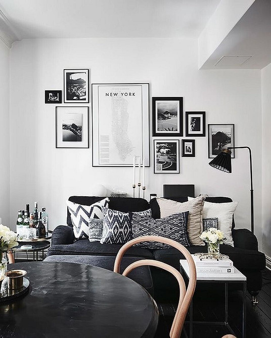 Стильний дизайн інтер'єру з використанням темних меблів та світлого декору для балансу кольорів.