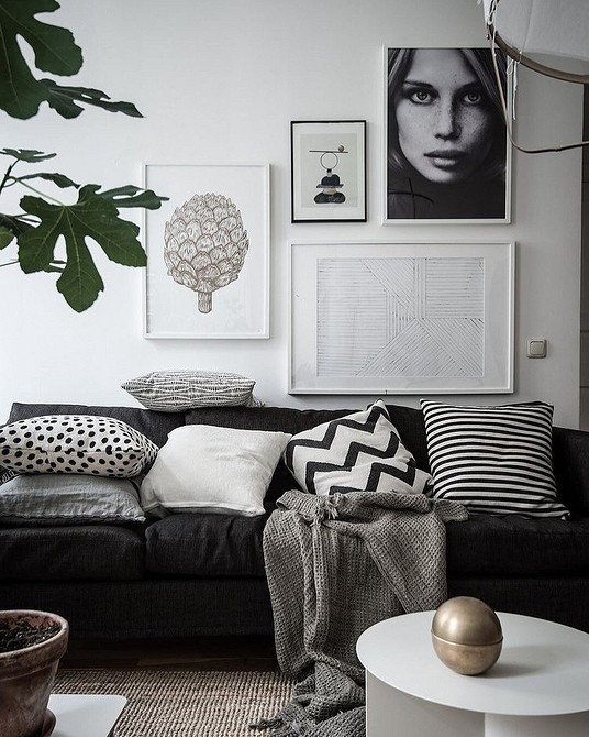 Дизайн вітальні з темними шкіряними меблями та світлими шторами на вікнах