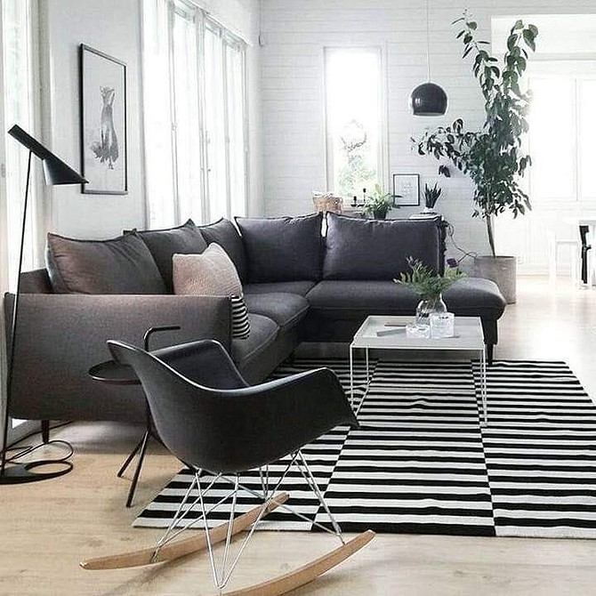 Дизайн вітальні з темною тумбою під телевізор, світлими стінами та мінімалістичним декором