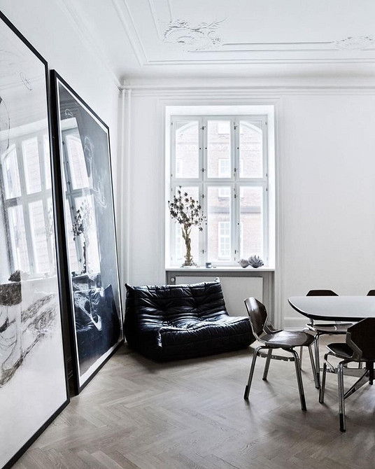 Дизайн інтер'єру з темним дерев'яним столом, світлим килимом та великим вікном