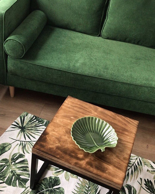 Круглий журнальний столик зі скляною стільницею в елегантній вітальні.