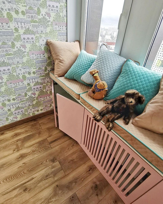 Диван на підвіконні з пледом та подушками, тепла та затишна атмосфера в будинку.