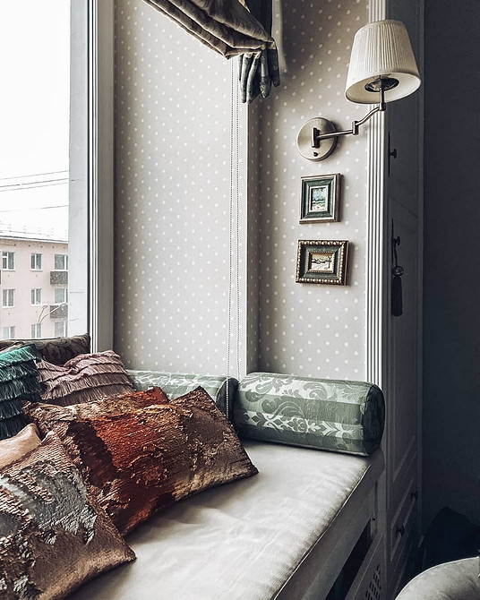 Організація дивану на підвіконні з використанням ящиків для зберігання речей.