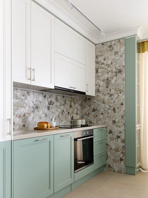 Елегантна біла кухня з мармуровою стільницею та золотими деталями.