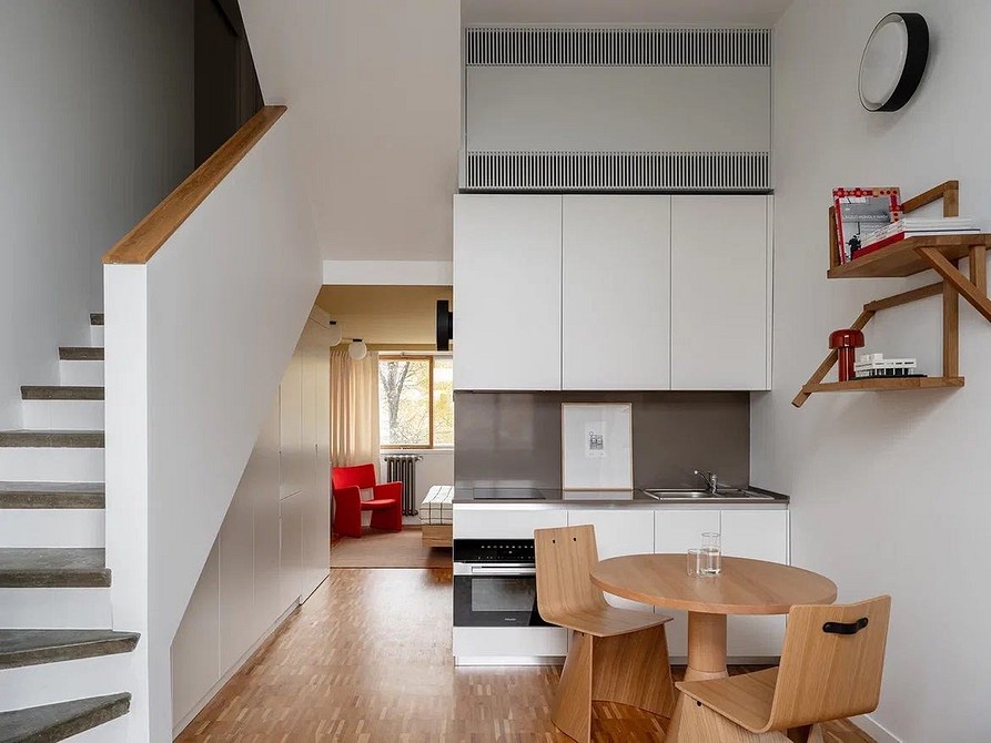 Кухня в скандинавському стилі з білими меблями та рослинами, що створюють атмосферу живості.