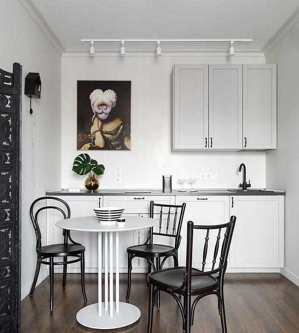 Біла кухня в класичному стилі з різьбленими фасадами та елегантною фурнітурою.