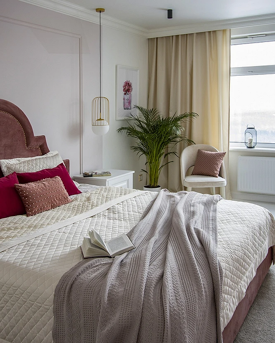 Інтер'єр спальні з білими меблями: шафа-купе, ліжко з м'яким узголів'ям та дзеркала.