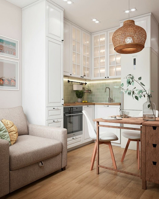 Біла кухня в скандинавському стилі з дерев'яними елементами та світлим інтер'єром.