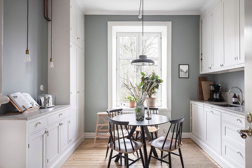 Біла кухня з акцентом на природне освітлення, просторий дизайн та зручні меблі.