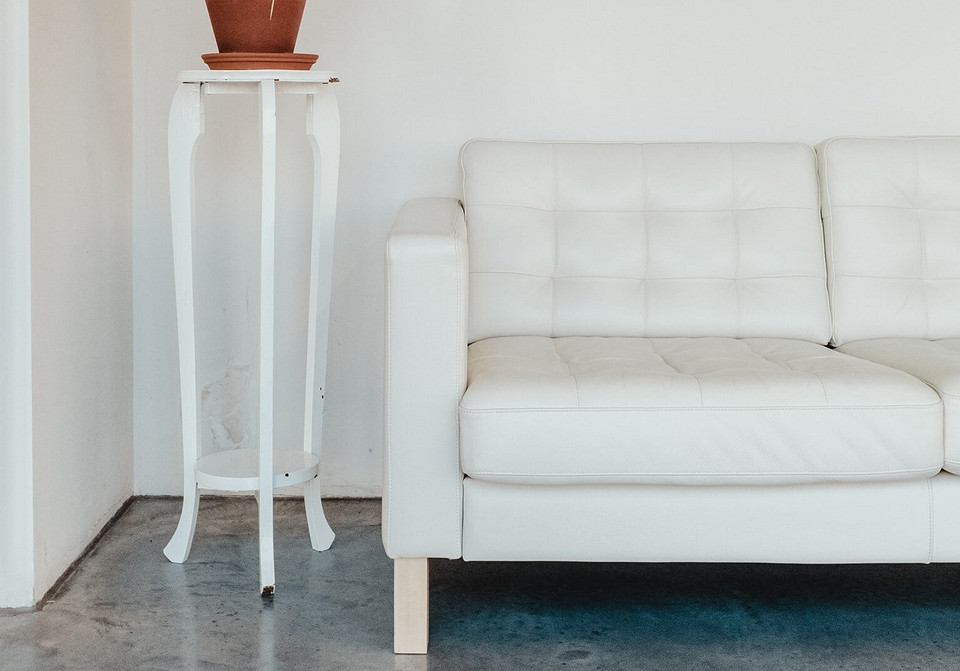 Сучасна вітальня з білим диваном та дерев'яними елементами декору.